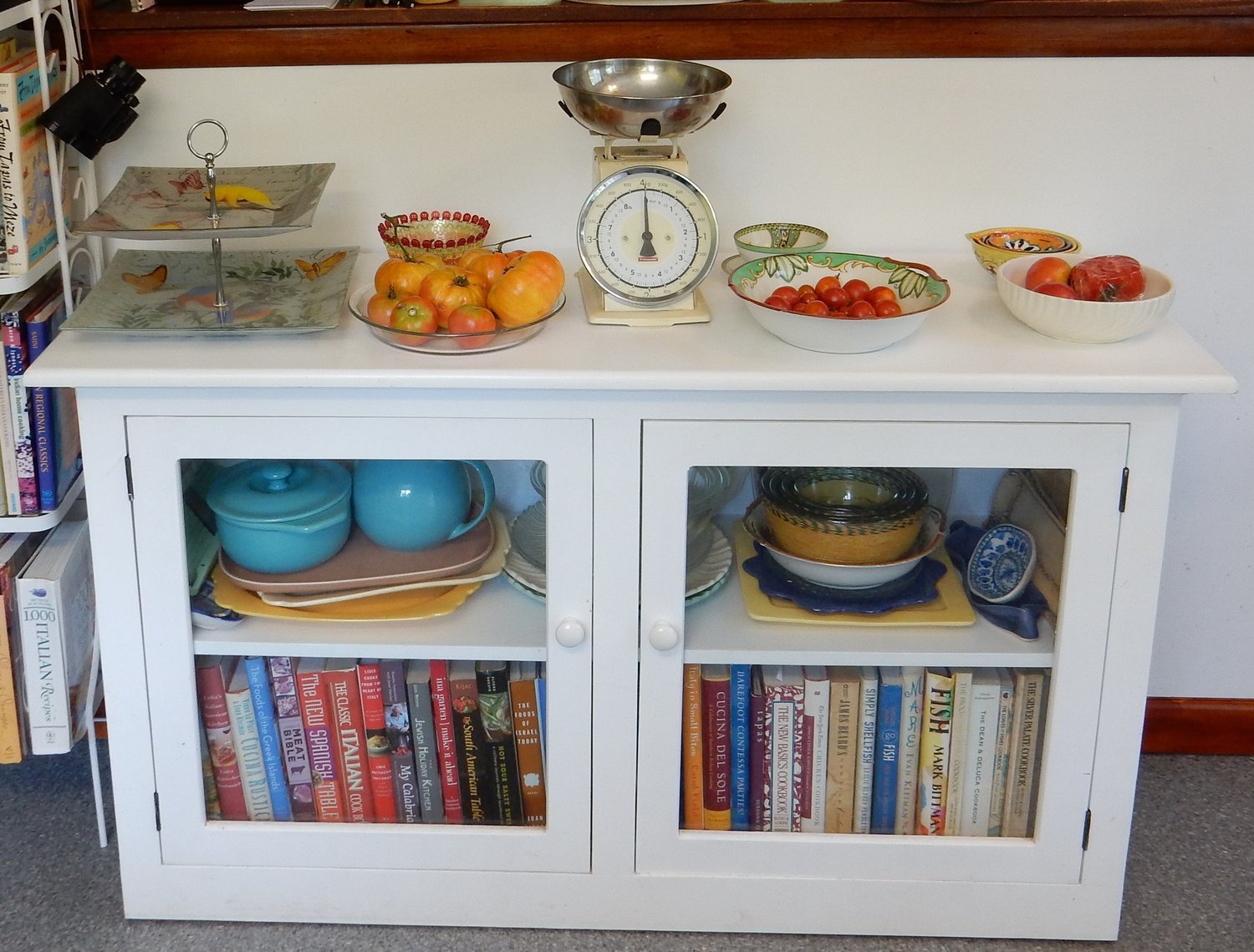 Cookbook cabinet and shelves for serving dishes.